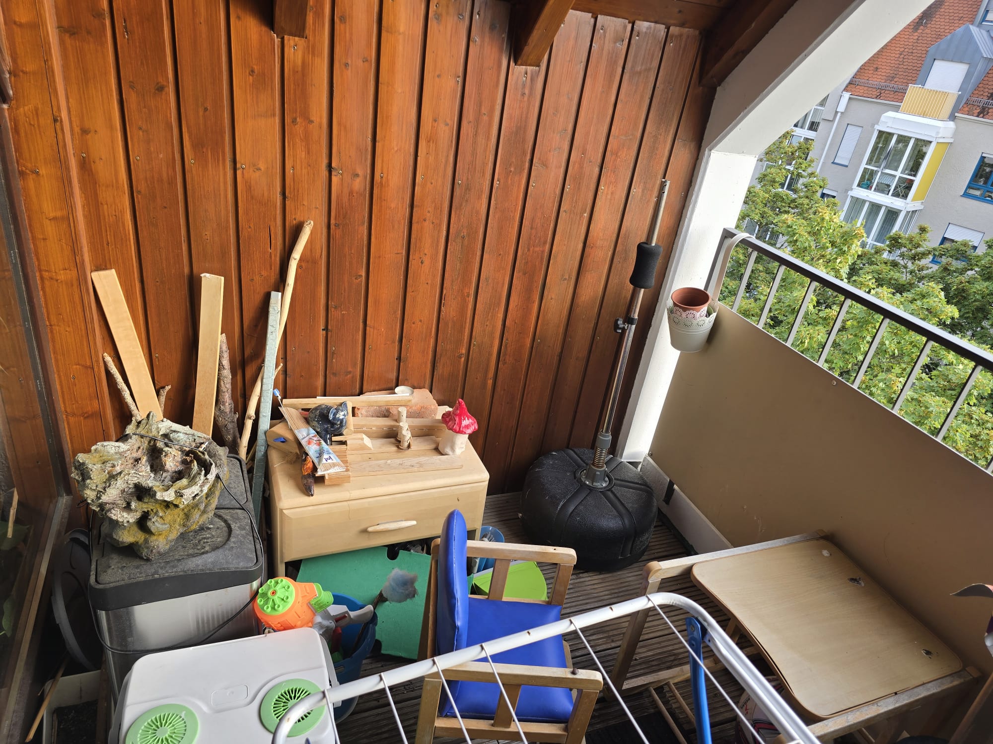 Der überdachte Balkon als Abstellfläche: Wäscheständer, Holzreste, Kinderspielzeug und Gartenmöbel stehen kreuz und quer