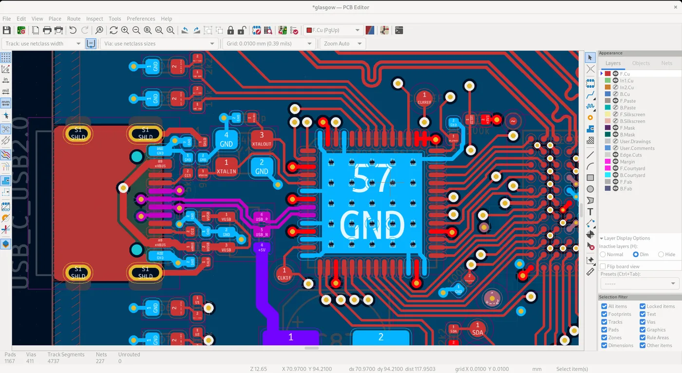 Bildschirmfoto des KiCad-Leiterplatten-Editors mit roten und blauen Leiterbahnen, einem großen Chip in der Mitte und der Ebenenliste am rechten Rand