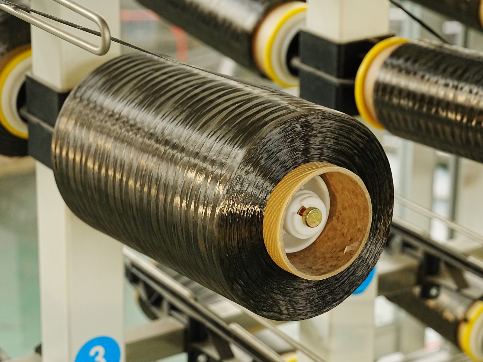 Spulen mit schwarzem Kohlefaser-Roving in einer Produktionsanlage